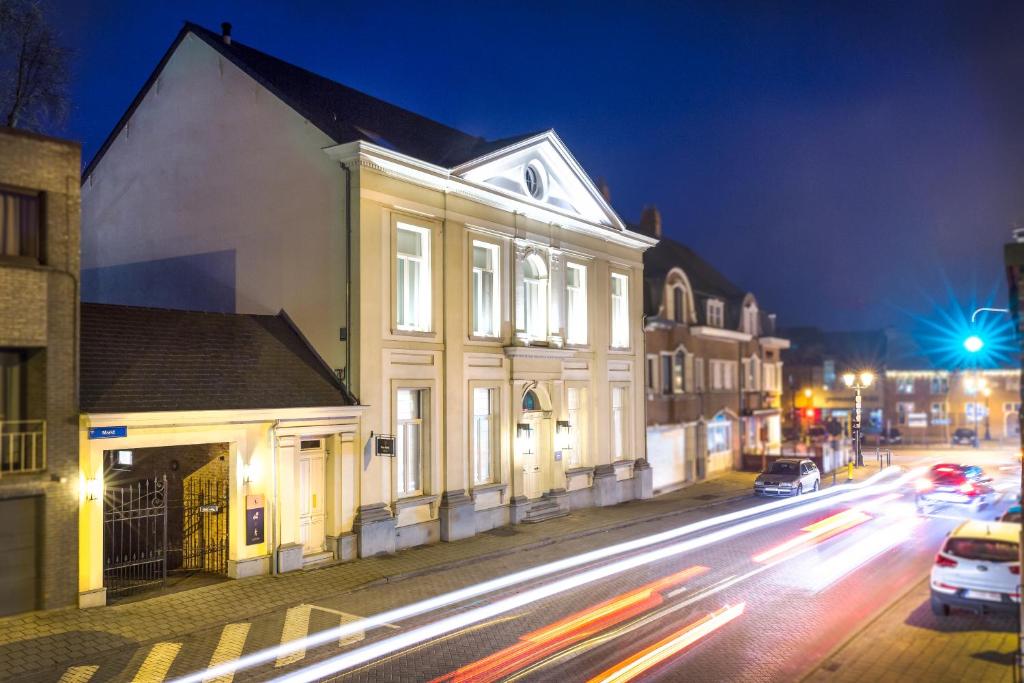 een stadsstraat 's nachts met gebouwen en auto's bij Logement Den Beer in Meerhout