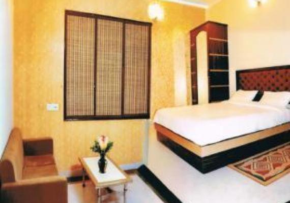 ein Schlafzimmer mit einem Bett, einem Tisch und einem Sofa in der Unterkunft Hotel Traditional Inn in Neu-Delhi