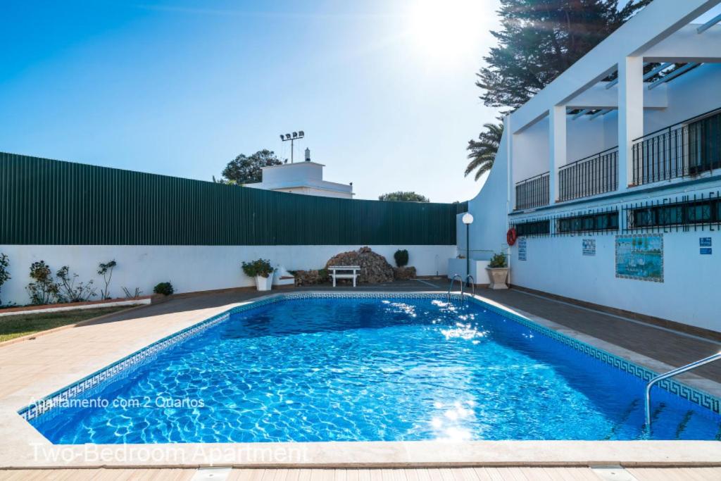 a swimming pool in front of a building at Akisol Albufeira Oura in Albufeira