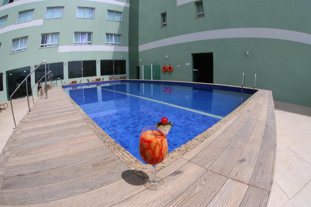 a chicken is sitting in front of a swimming pool at Real Classic Bahia Hotel in Salvador