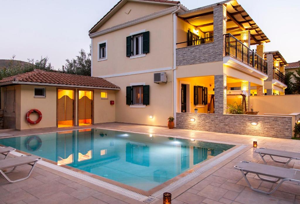 a villa with a swimming pool in front of a house at Azalea in Vasiliki