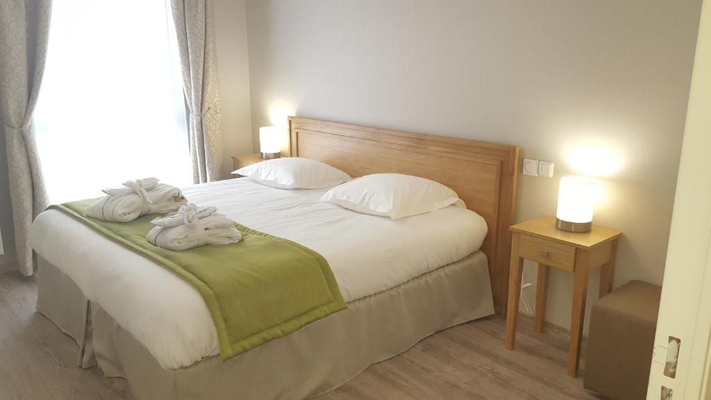 Ένα ή περισσότερα κρεβάτια σε δωμάτιο στο Résidence Séniors Domitys Les Hautes Feuilles