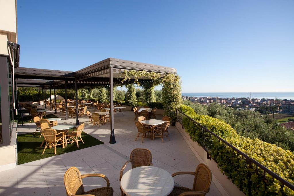 a patio with tables and chairs on top of a building at Villa Maria Hotel & SPA in Francavilla al Mare