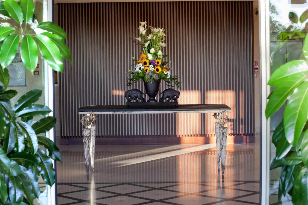 a table with a vase of flowers on it at Villa Maria Hotel & SPA in Francavilla al Mare