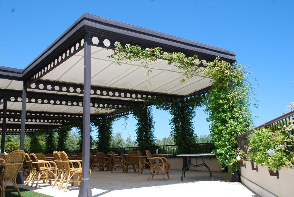 a pergola with chairs and tables under it at Villa Maria Hotel & SPA in Francavilla al Mare