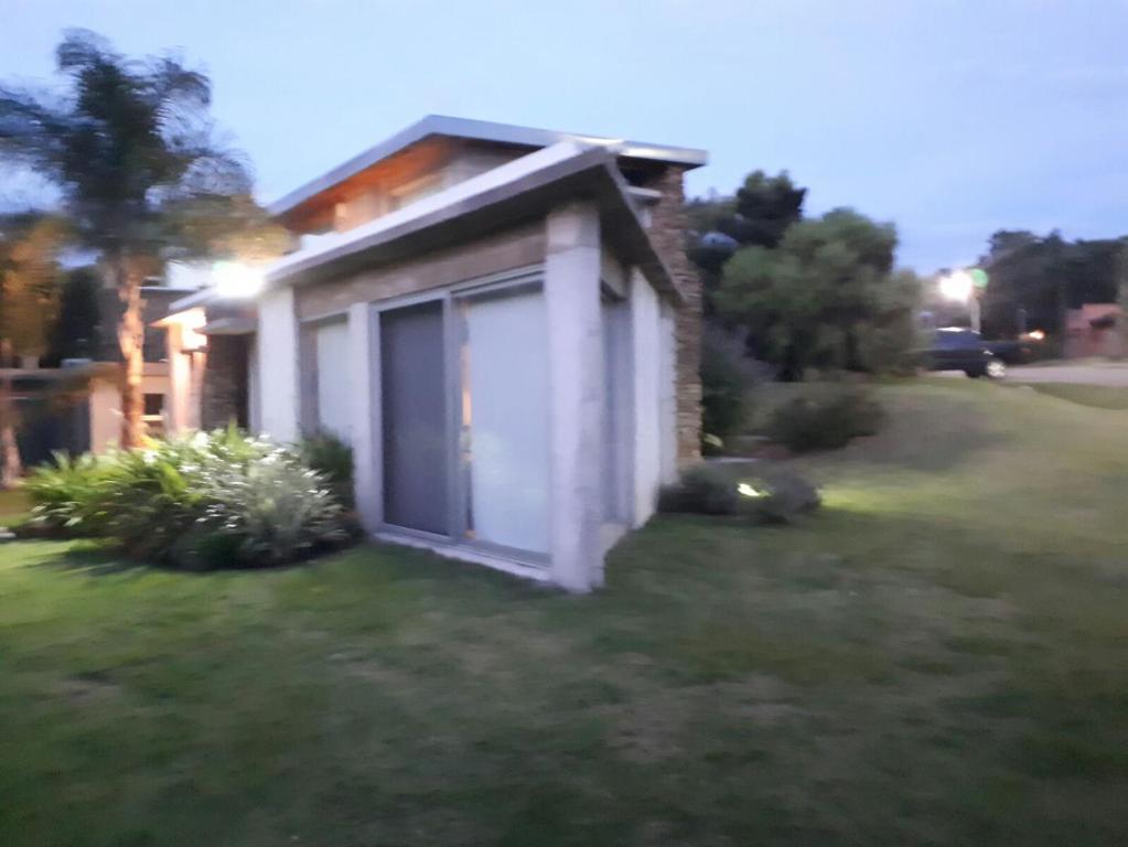 a small house with a door in the grass at Loft del barranco in Colonia del Sacramento