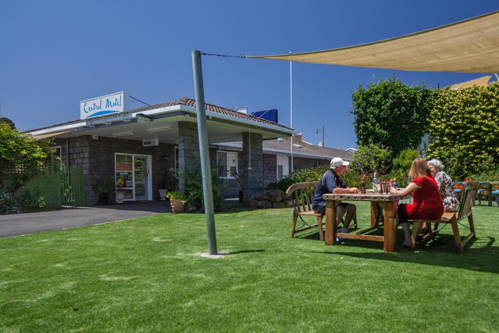 un grupo de personas sentadas en una mesa en un patio en Central Motel Port Fairy en Port Fairy