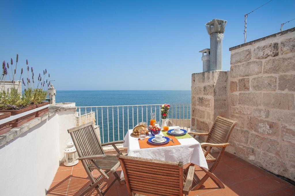 a table and chairs on a balcony with the ocean at Elena's House 6 in Polignano a Mare