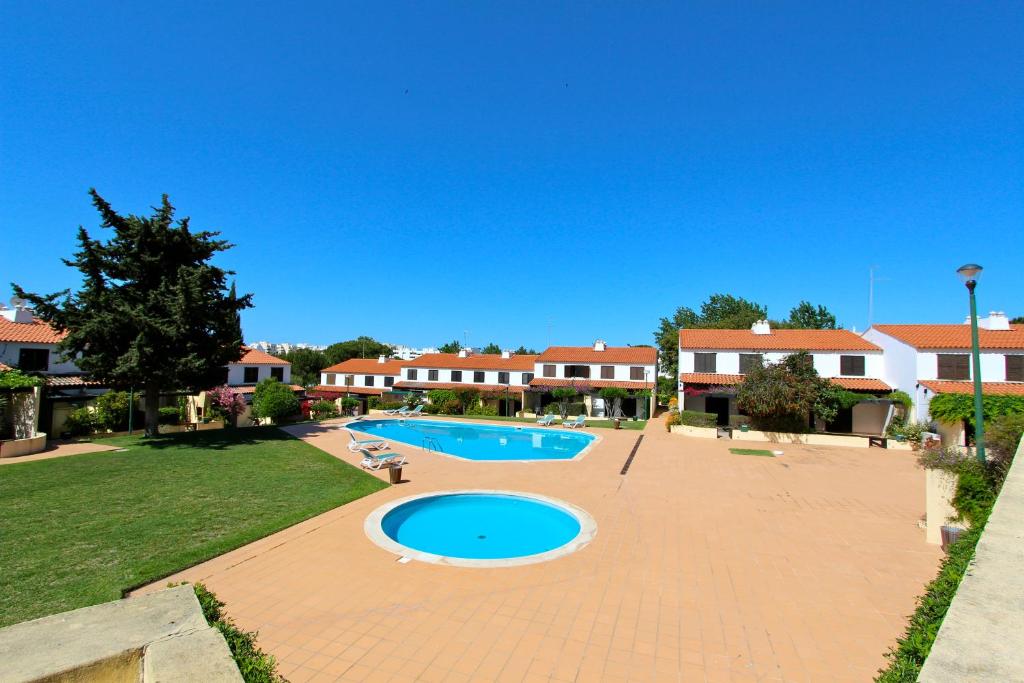 a swimming pool in the middle of a yard at Vilar do Jardim 59 - Clever Details in Vilamoura