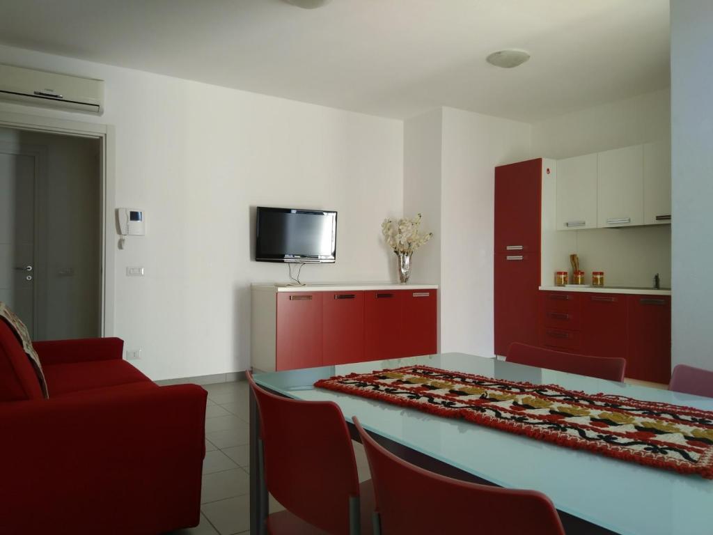 トルトリにあるAppartamenti Demurtasのテーブル、椅子、テレビが備わる客室です。
