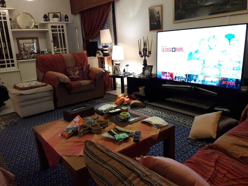 een woonkamer met een grote televisie en een tafel bij Shared Top 1st floor villa in Limassol