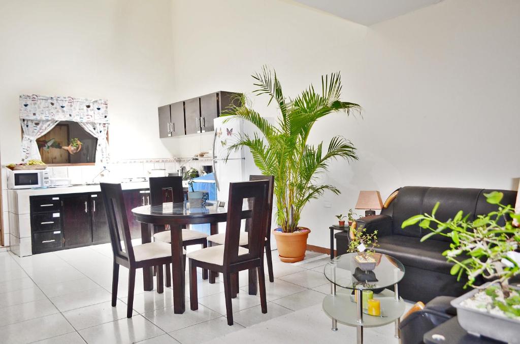 uma cozinha e sala de estar com mesa e cadeiras em Guesthouse Casa Lapa em Alajuela