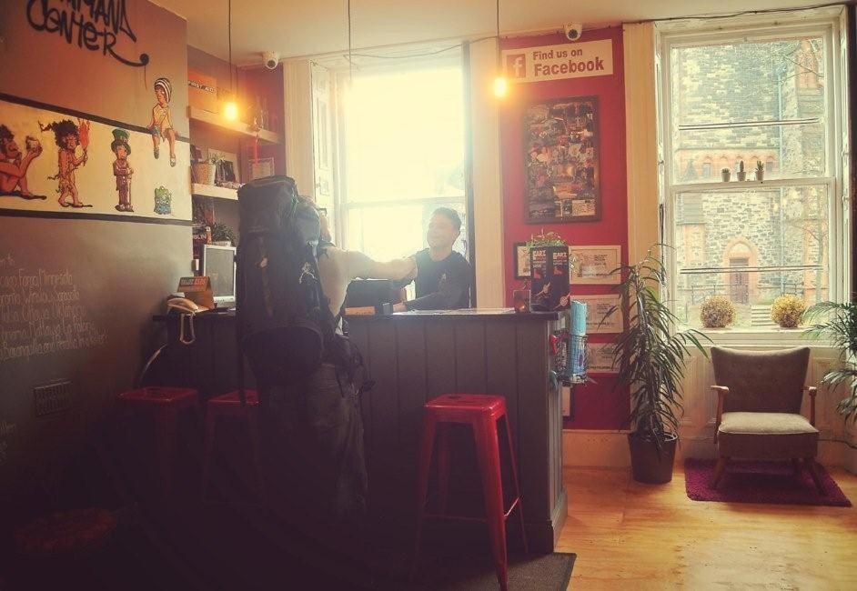 a woman sitting at a counter in a restaurant at Vagabonds Hostel in Belfast