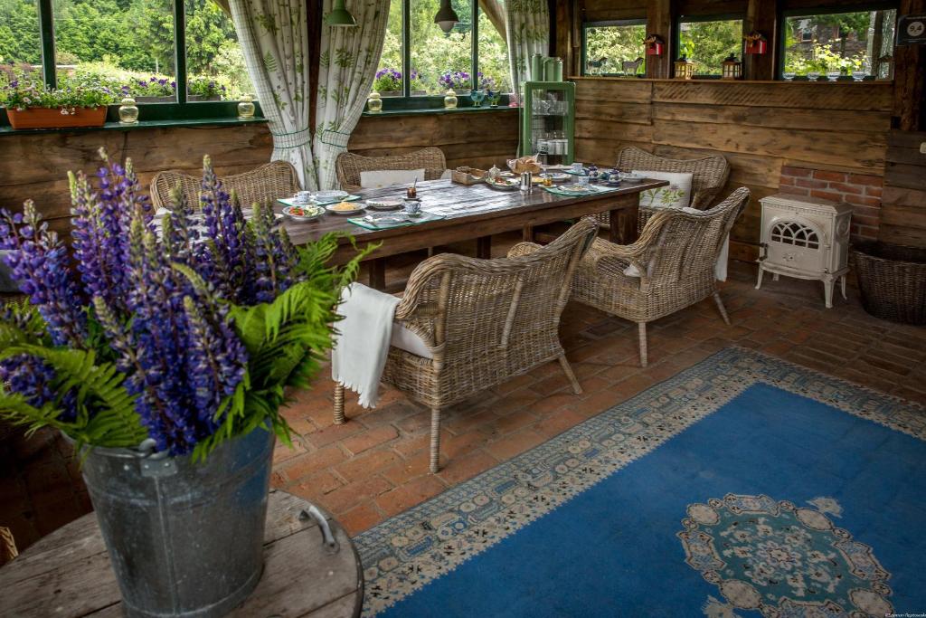 un patio con tavolo, sedie e fiori viola di Pan tu nie spal a Gałkowo