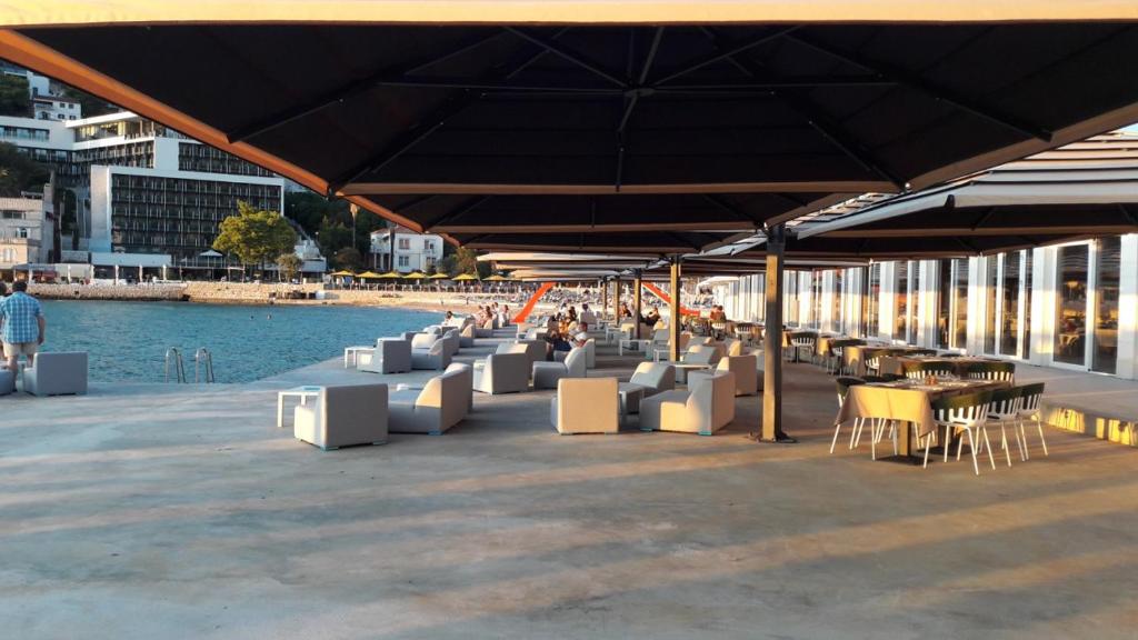 a group of tables and chairs under a large umbrella at Ana Guesthouse in Dubrovnik