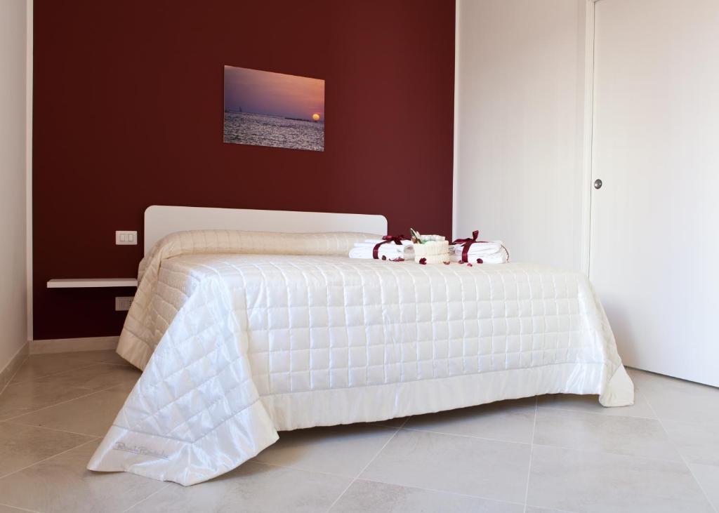 a bedroom with a white bed with two stuffed animals on it at B&B Petali in Trapani