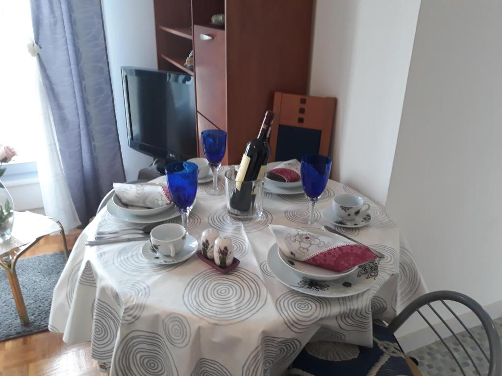 a table with a white table cloth on it with plates and cups at Apartment Karlos in Zagreb