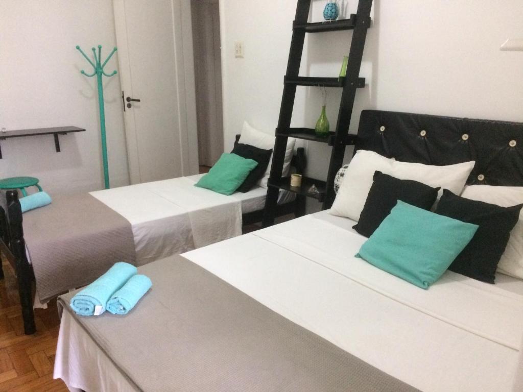 duas camas num quarto com verde e branco em Méier House no Rio de Janeiro