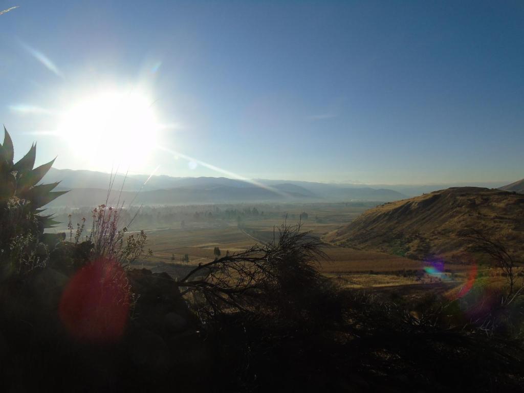 a view of a valley with the sun in the sky at Pousada Villa Huaripampa in Jauja