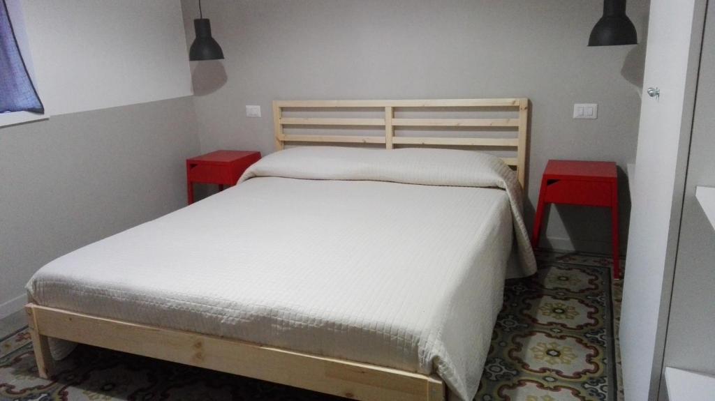 una camera con un letto e due tavoli rossi di Casa Le Cementine a Verbania