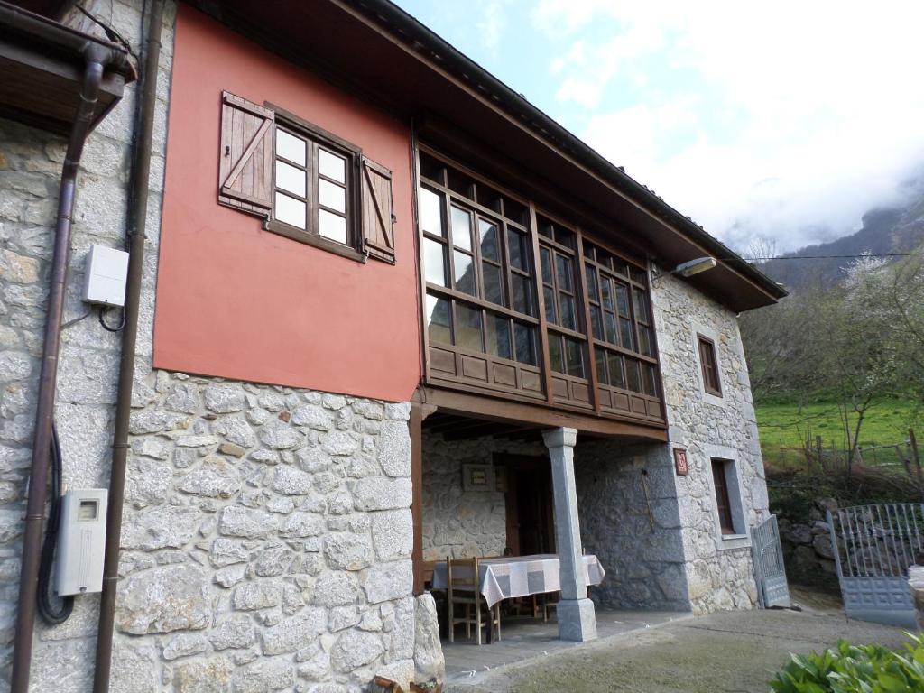 uma vista exterior de um edifício com uma mesa exterior em La Tanda em Taranes