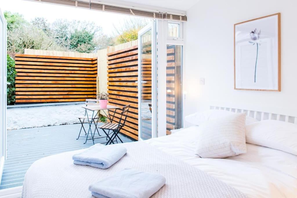 a bedroom with a white bed and a balcony at The Annexe in Bournemouth