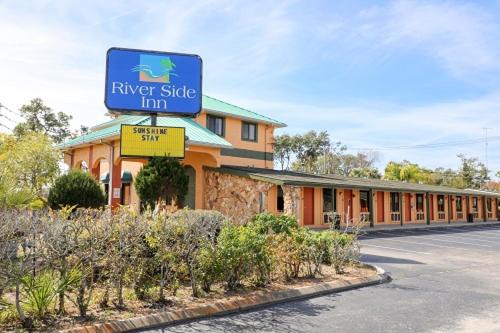 un hotel con un cartel para una posada junto al río en River Side Inn New Port Richey, en New Port Richey