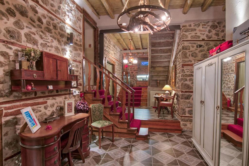 a room with stone walls and a table and chairs at Bayiri Petit Pension in Litochoro