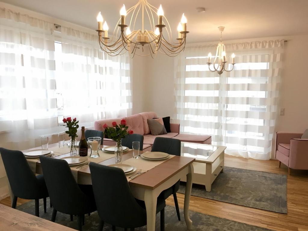 a dining room with a table and a couch at White Vintage Park View Apartment in Vienna