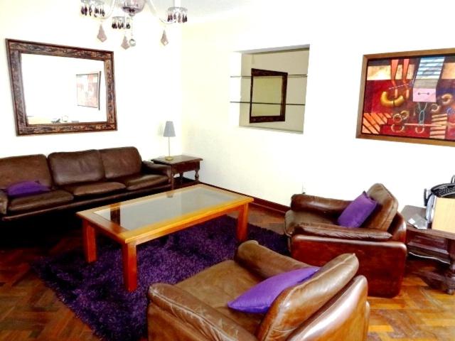 sala de estar con muebles de cuero y mesa de centro en Roma, en Lima
