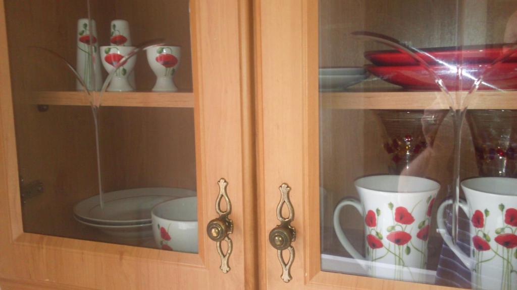 a glass cabinet with cups and dishes in it at Nick & Sandra's in Slane