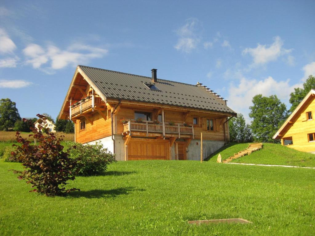 une grande maison en bois sur une pelouse verdoyante dans l'établissement Chambres d'hôtes La Vercouline, à Villard-de-Lans