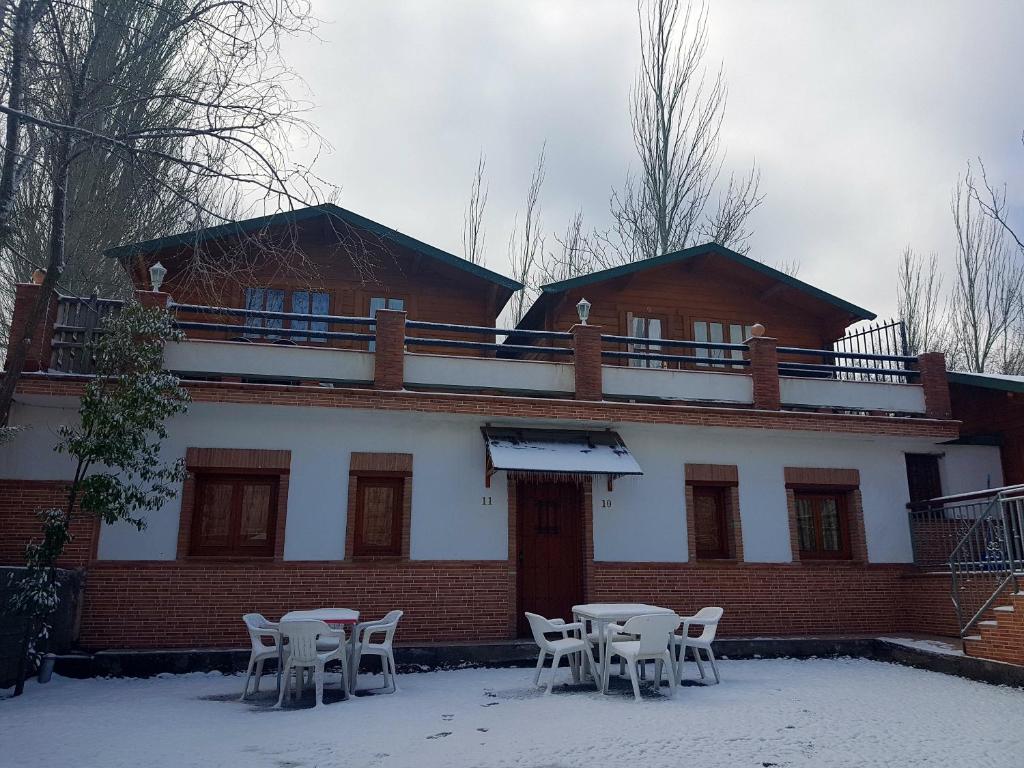 a building with tables and chairs in the snow at Camping Ruta del Purche in Monachil