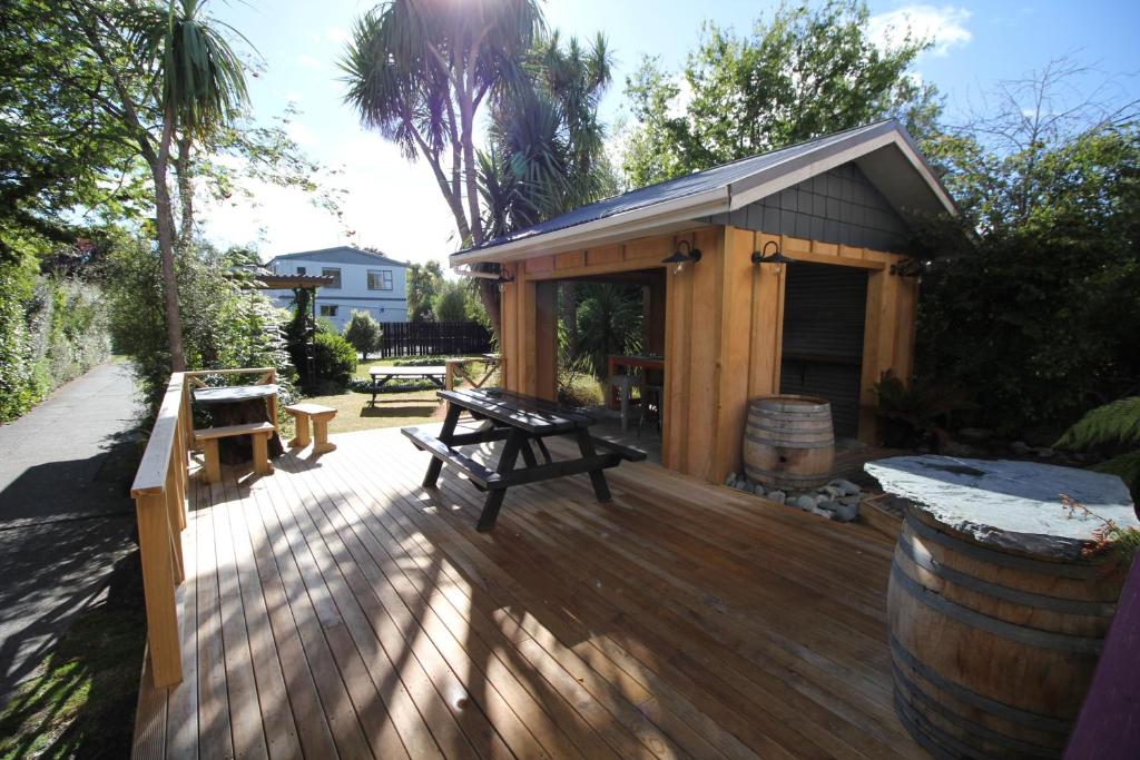 a wooden deck with a picnic table and a building at Te Anau Lakefront Backpackers in Te Anau