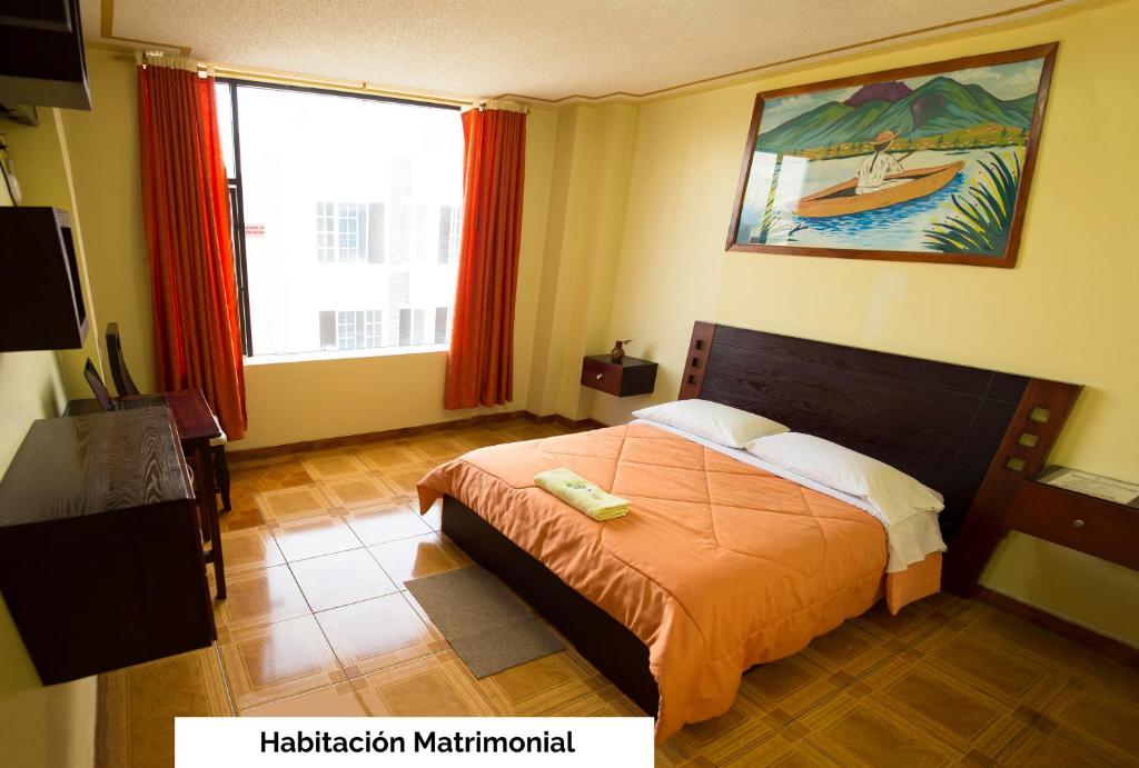 a bedroom with a bed and a large window at Mashy´s Hostal in Otavalo