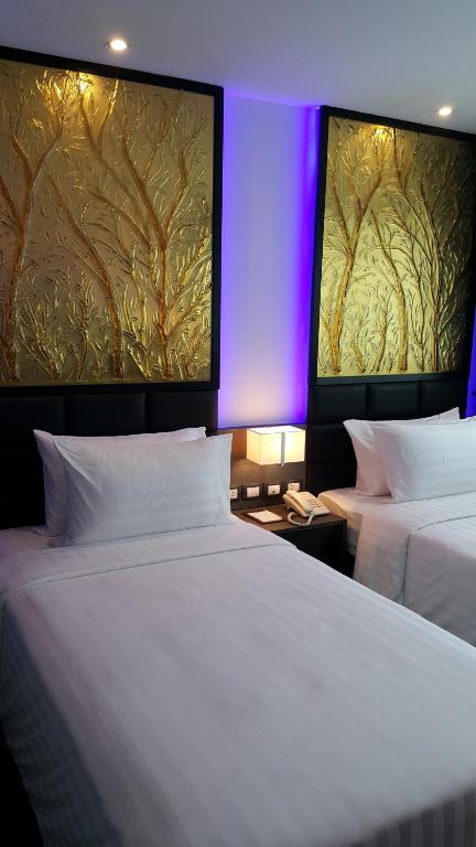 Postel nebo postele na pokoji v ubytování Nova Express Pattaya Hotel