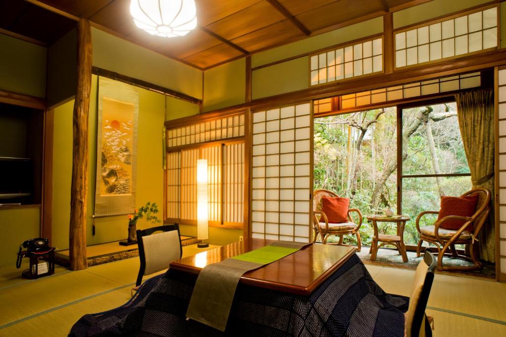 um quarto com uma mesa e cadeiras e uma janela em Yamagaso em Hakone