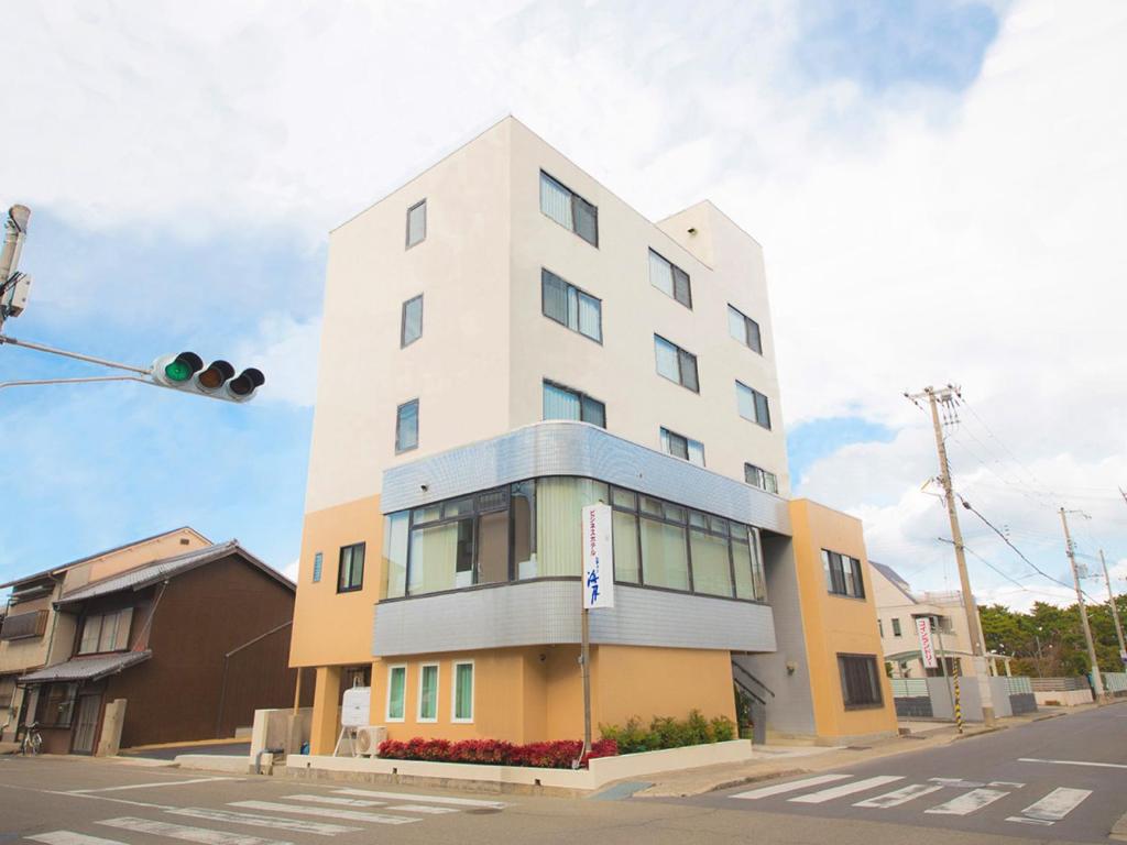 un grand bâtiment blanc au coin d'une rue dans l'établissement City Kaigetsu, à Sumoto