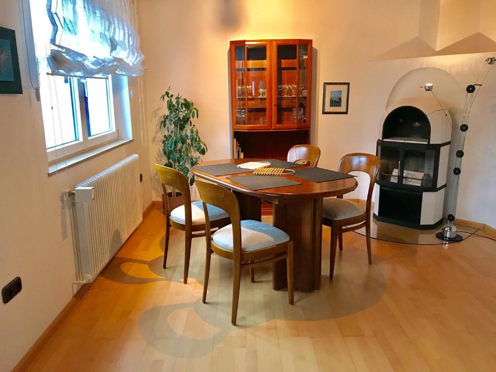 a dining room with a table and chairs and an oven at Gästehaus Kaiser in Ostfildern