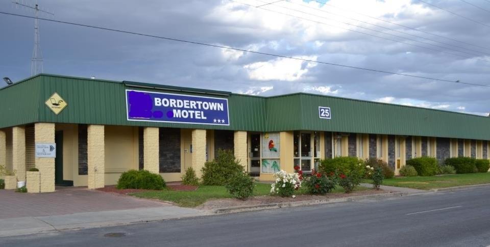 um edifício com um sinal que diz motel bordederation em Bordertown Motel em Bordertown