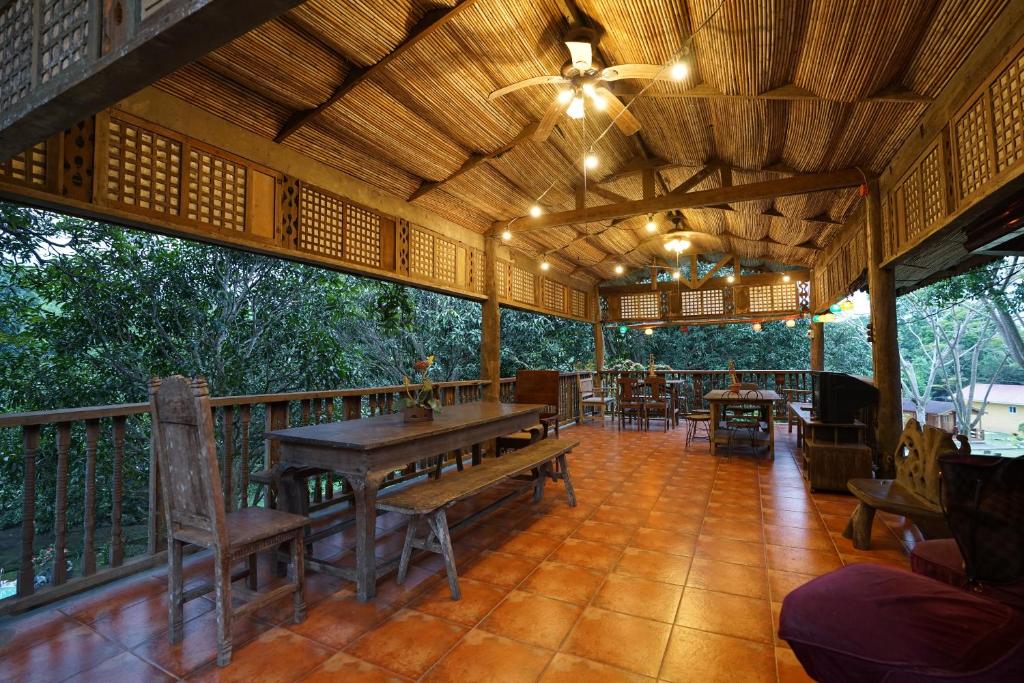 ein Restaurant mit einem Tisch und Stühlen auf einer Terrasse in der Unterkunft Plantacion Isabelle in Taal
