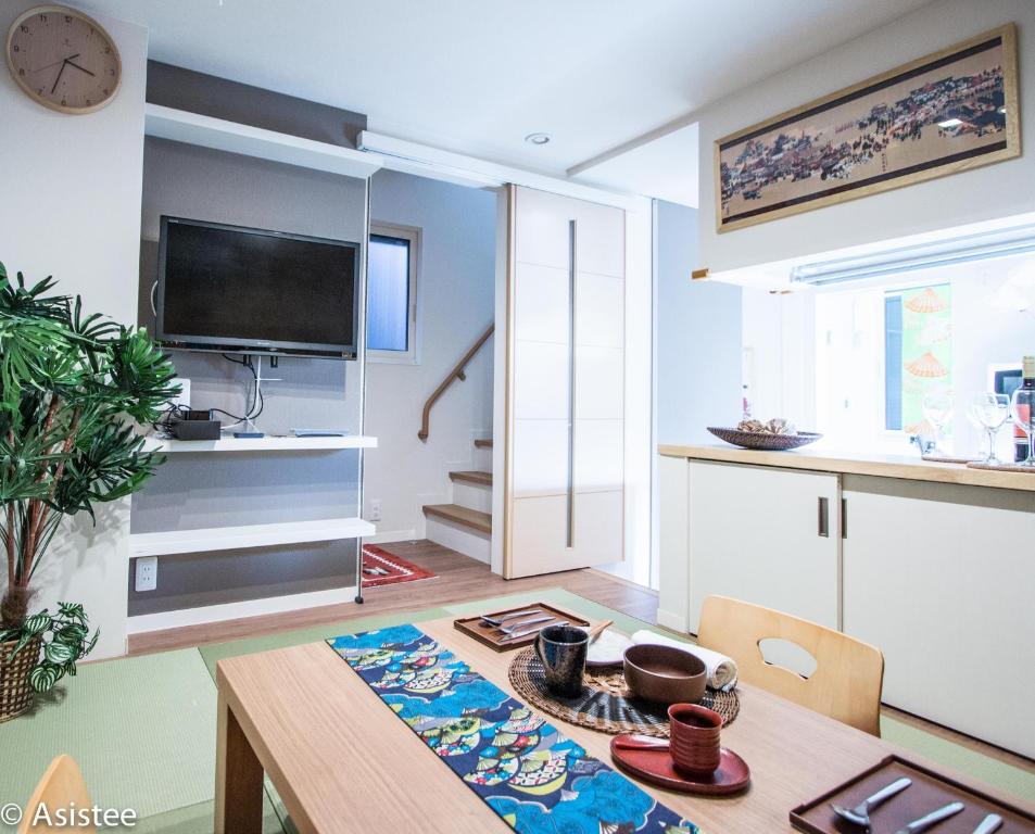 een eetkamer met een tafel en een tv bij Modern Machiya-Babacho in Kyoto