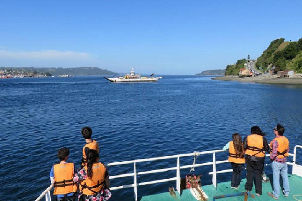 a group of people on a boat in the water at Chiloe Domos Curaco de Vélez in Curaco de Velez