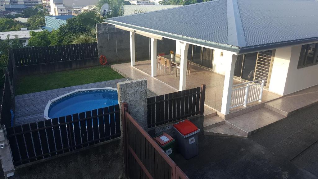 uma casa com uma piscina e uma cerca em "Hanikea" Quiet & Pool Home em Papeete