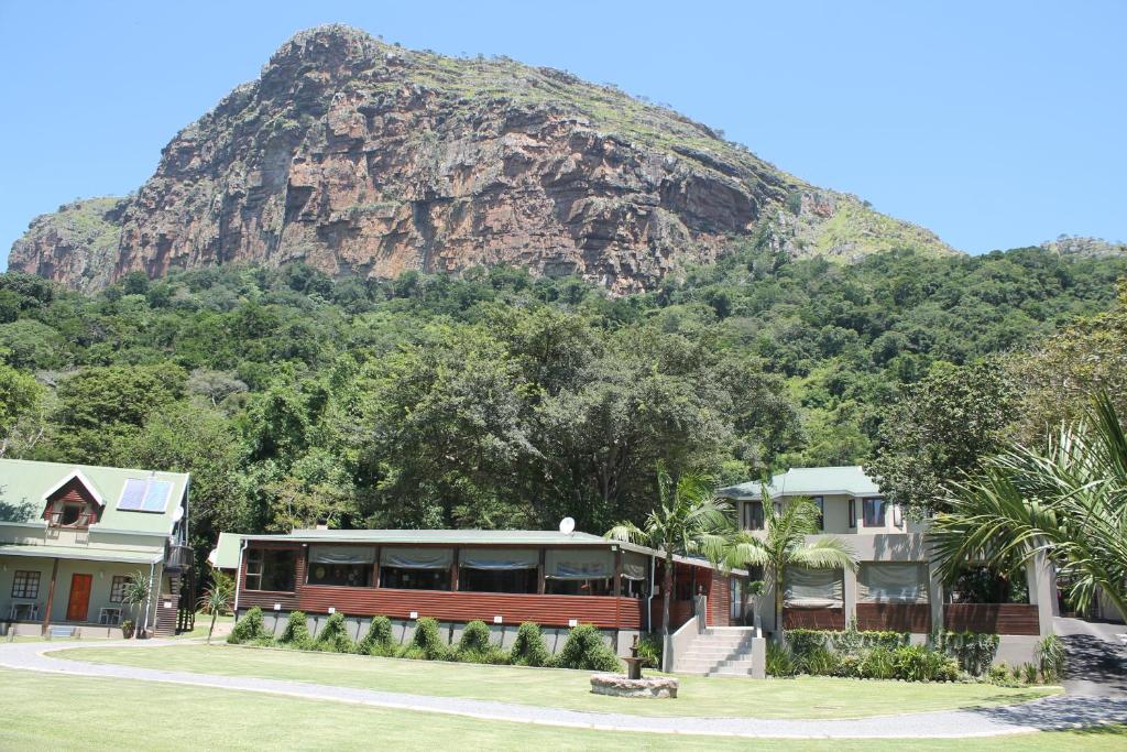 a building with a mountain in the background at Port St Johns River Lodge in Port St. Johns