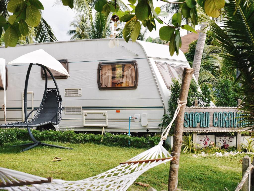 a white caravan with a hammock in front of it at Samui Caravans in Laem Sor