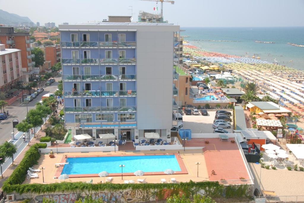 a hotel with a swimming pool in front of a beach at Hotel Majestic in Pesaro