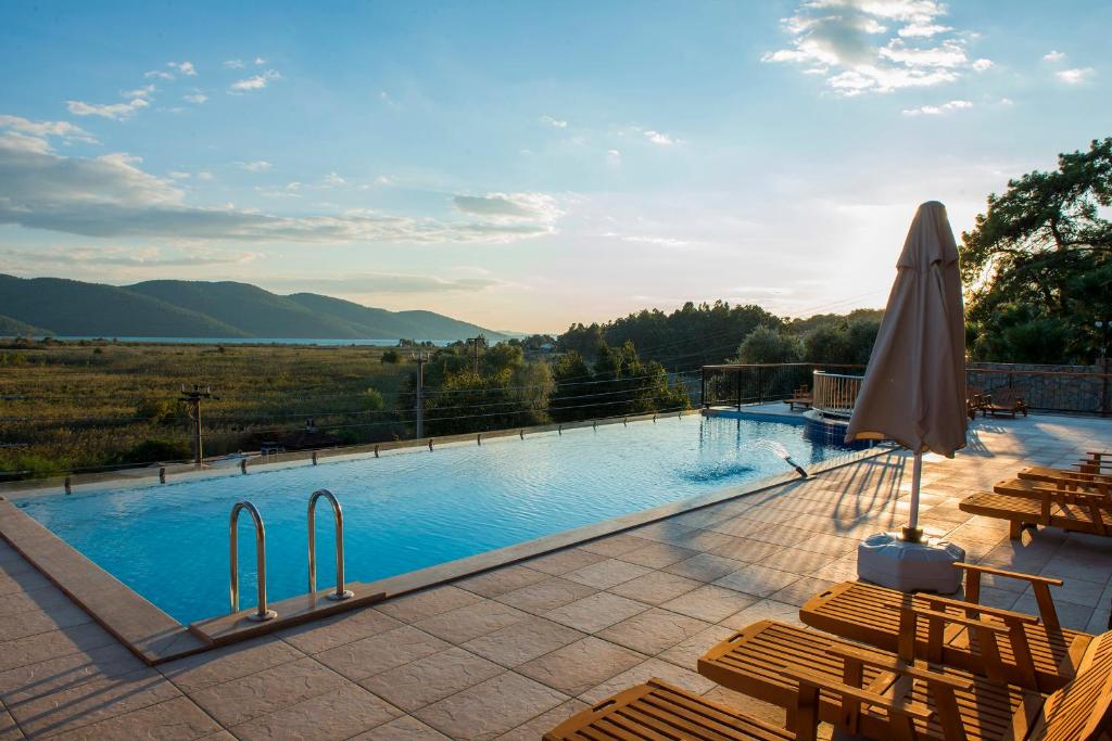 a large swimming pool with chairs and an umbrella at Grand Hotel Azmakhan Spa&Welness in Akyaka