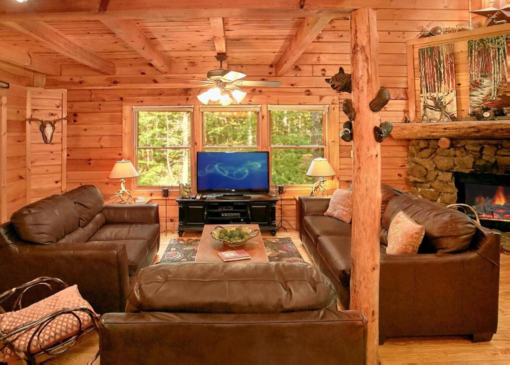 uma sala de estar com sofás e uma televisão numa cabina em Creekside Oasis #3 em Sevierville