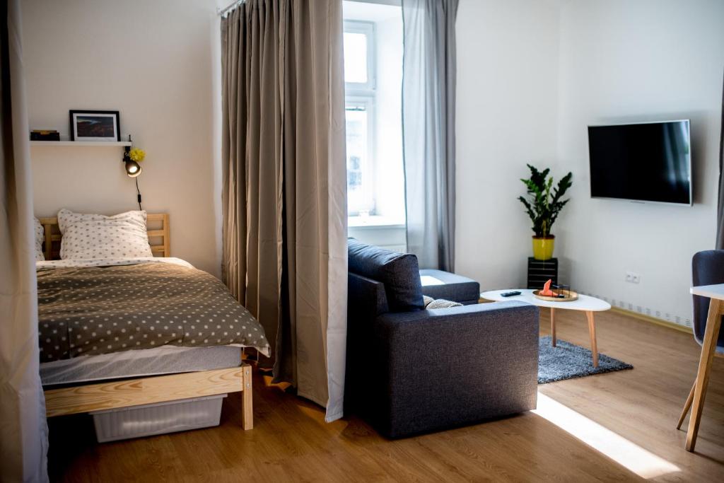 um quarto com uma cama e uma cadeira e uma televisão em Apartmán v centru em Šumperk